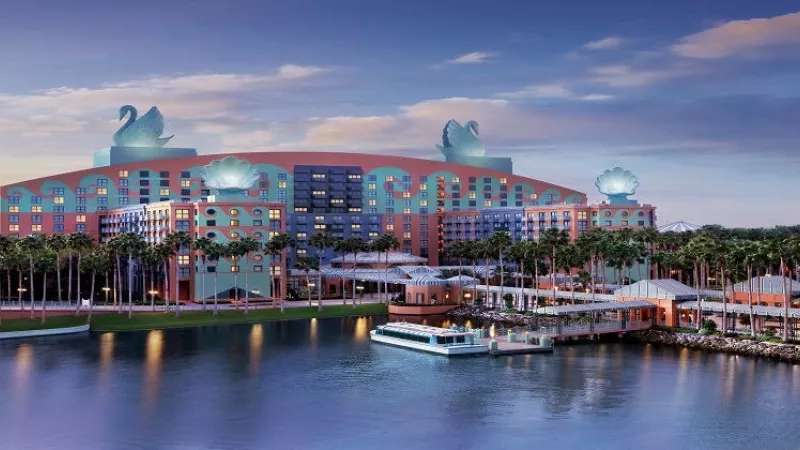 Exterior view of Swan and Dolphin Resort with a boat sailing in the foreground.