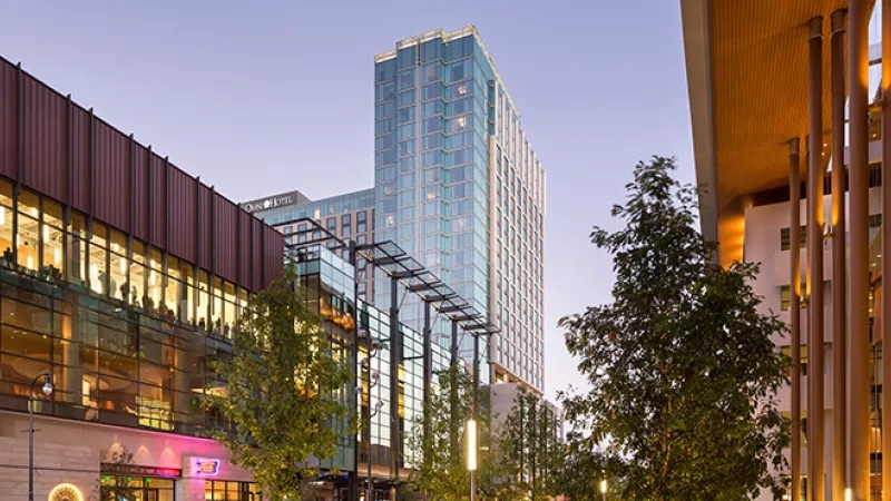 Omni Nashville Hotel building, city view with trees and lights, architecture, and a lively urban ambiance.