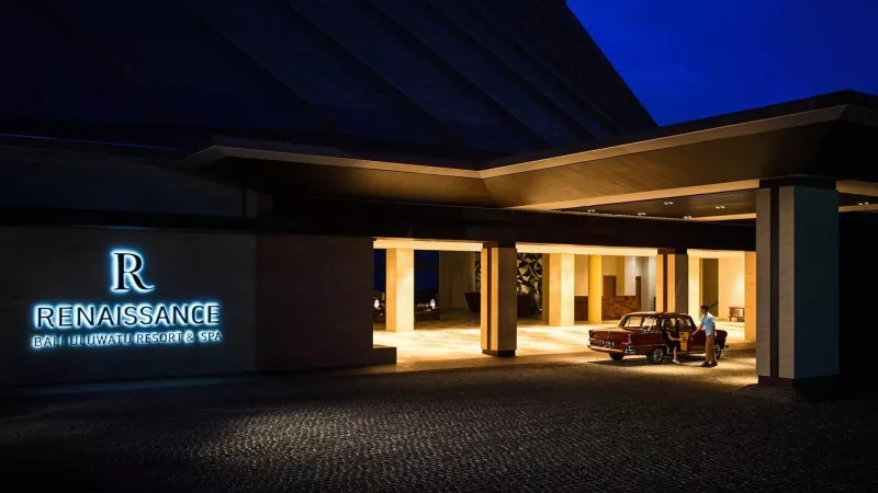 Renaissance Bali Uluwatu Resort & Spa entrance at night with a car parked in front of the entrance.