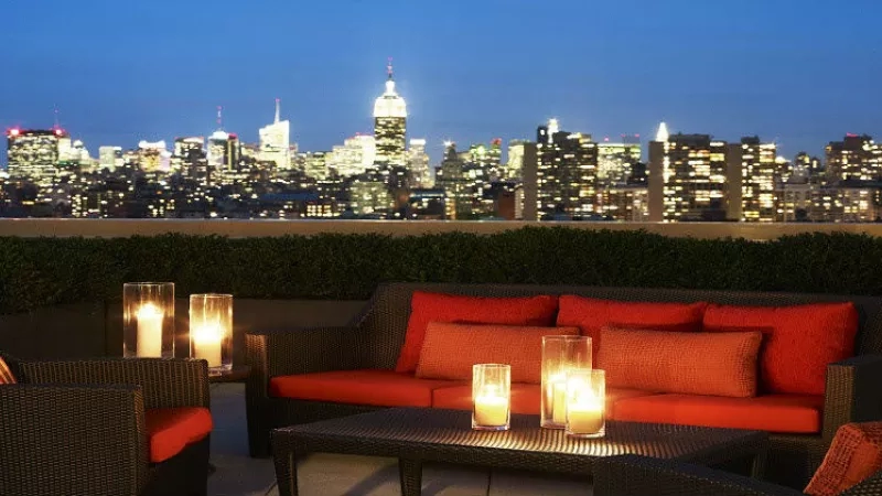 Rooftop lounge with skyline view at night at Sheraton Tribeca New York Hotel.