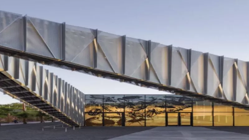 Exterior of Santa Fe Children's Museum with large bridge and glass walls with an image of insects.