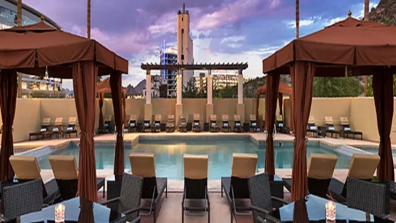 Tempe Mission Palms Hotel outdoor pool with lounge chairs and cabanas at dusk.