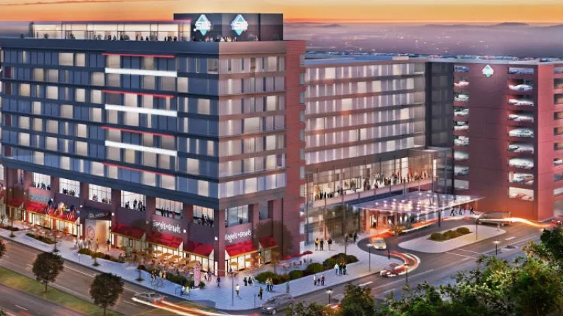 The Hotel UMD exterior with cars and people at night, featuring architecture, landscaping, and ambiance.