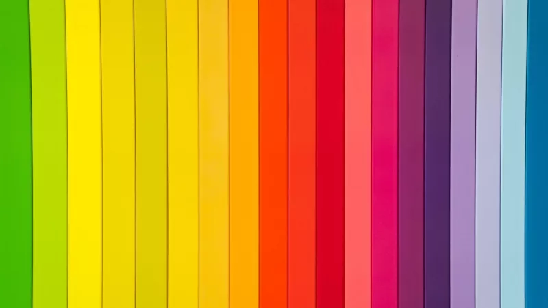 A collection of vertical colored paper sheets arranged from yellow to blue, showcasing vibrant colors and textures.