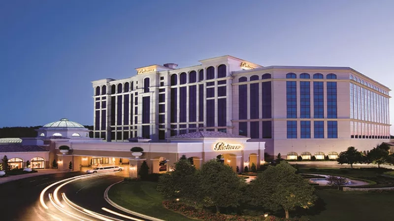 Dusk view of Belterra Casino Resort and Spa with lush landscaping and a luxury vehicle approaching the entrance.