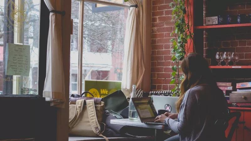 Woman working on laptop in the window seat of the cafe at the Local Hub, Spokane.