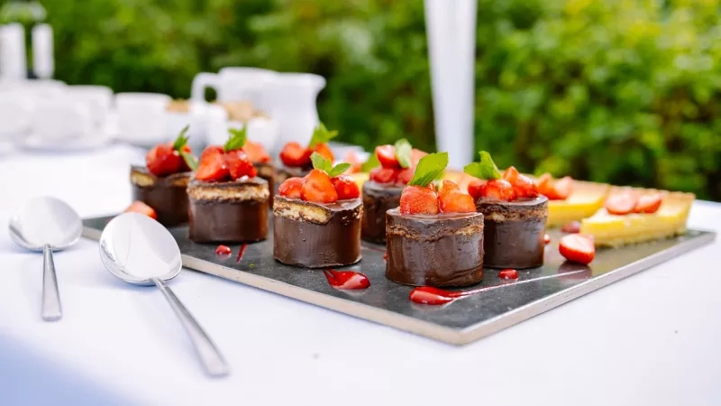 Tray of chocolate desserts on a table with spoons at an outdoor wedding reception at the Plaza Hotel.