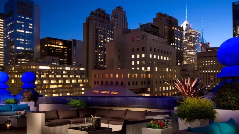 The Ritz-Carlton NYC rooftop bar with cityscape and contemporary design elements, evoking a luxurious ambiance.