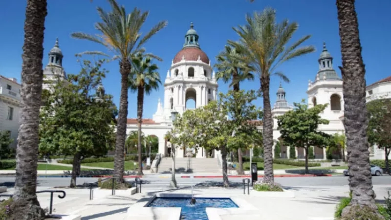 Pasadena City Hall, surrounded by trees and a fountain, in a bright, sunny day.