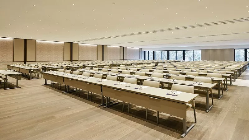 Wide conference room at The Westin Osaka with many desks and chairs and lots of windows.