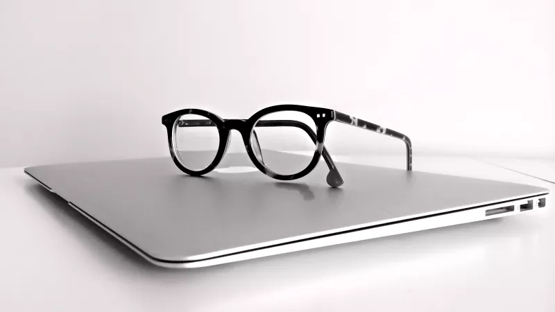 Glasses on a laptop, with a minimalist design, black-and-white, and a modern ambiance.