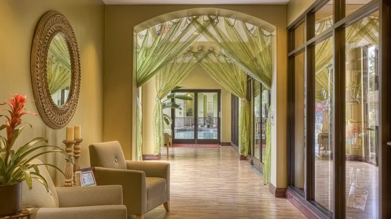 Hotel architectural tourism travel features a long hallway with chairs, a large pool, and curtains, creating an elegant ambiance.