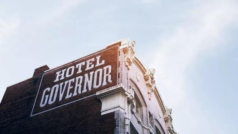 Hotel Governor, a building with text, architecture, and a blue sky with clouds in the background.