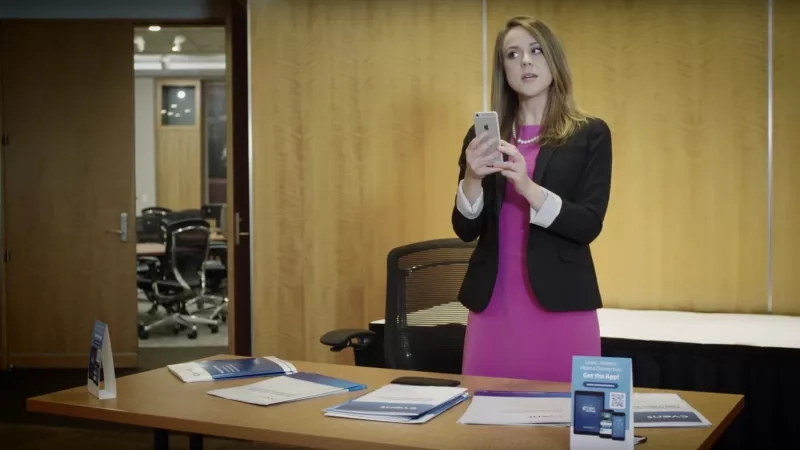 A woman standing in front of a desk with pamphlets and brochures on it.
