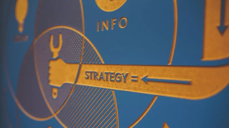 Close up of a marketing board with the word strategy on it and an arrow pointing right.