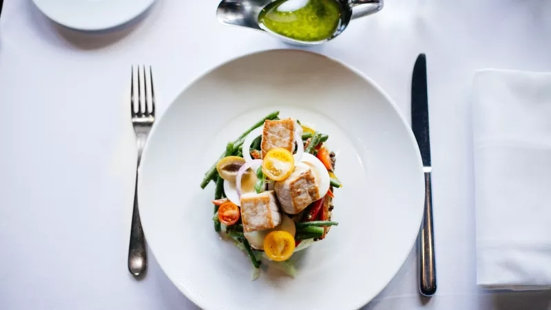 Plate of food with knife and fork on a table in The Boathouse, Melbourne.