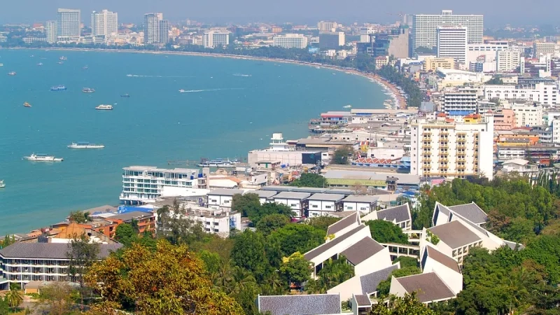 Pattaya Beach view from the top with boats, buildings, and trees during the daytime.