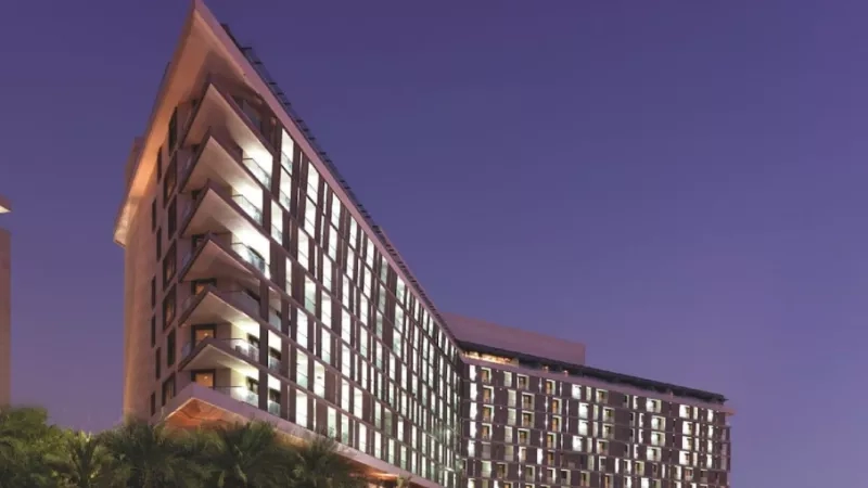The architecture of the Radisson Blu Hotel in Abu Dhabi, with landscaping and a nighttime ambiance.