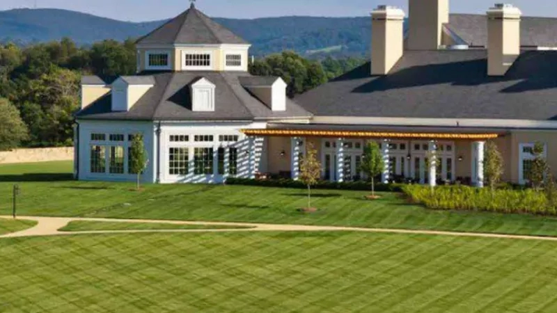 A mansion with a wide lawn and trees, showcasing its architecture, landscaping, and ambiance.