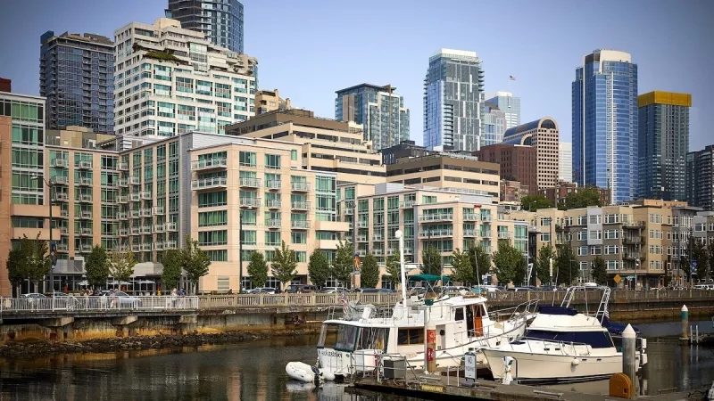 Waterfront view of buildings with boats docked along the shore on a sunny day in Seattle.
