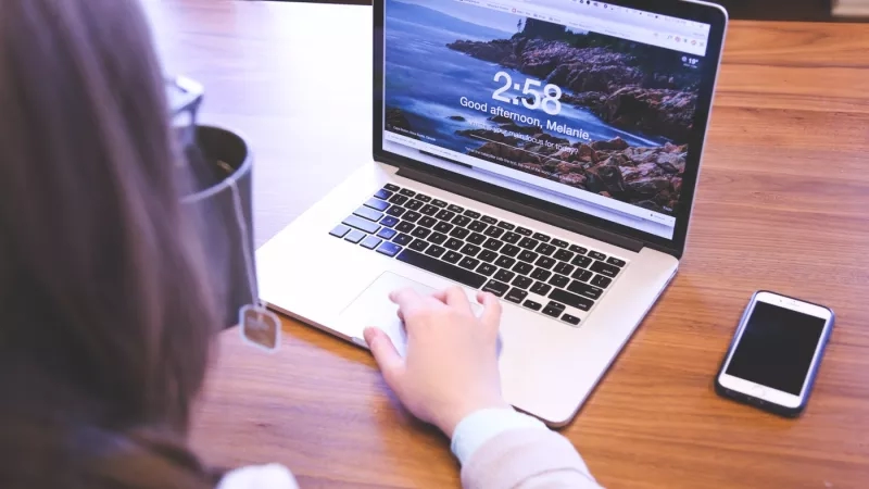 A woman working on a laptop with the text 2:58 Good afternoon, Melanie.