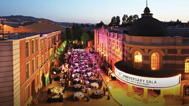 An aerial view of the anniversary gala, featuring a building, architecture, lighting, and people.