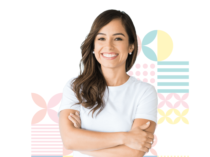 A woman with her arms crossed in front of a green background with colorful patterns.