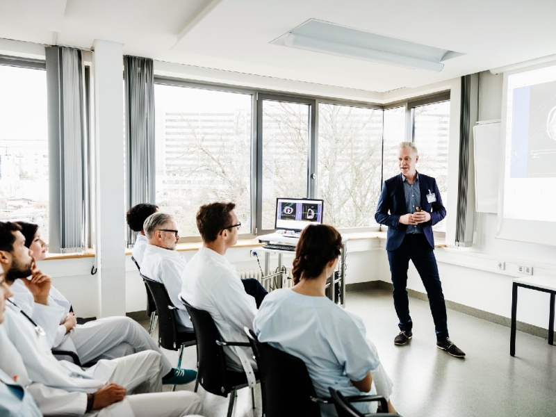 Male doctor giving a presentation to medical students in a lecture hall