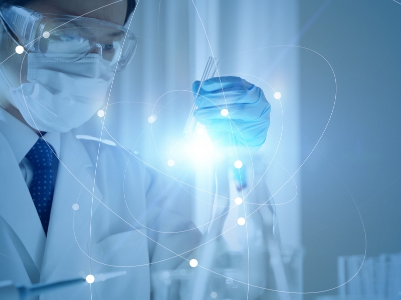 Scientist working in lab with test tubes super imposed over abstract molecule model in blue.