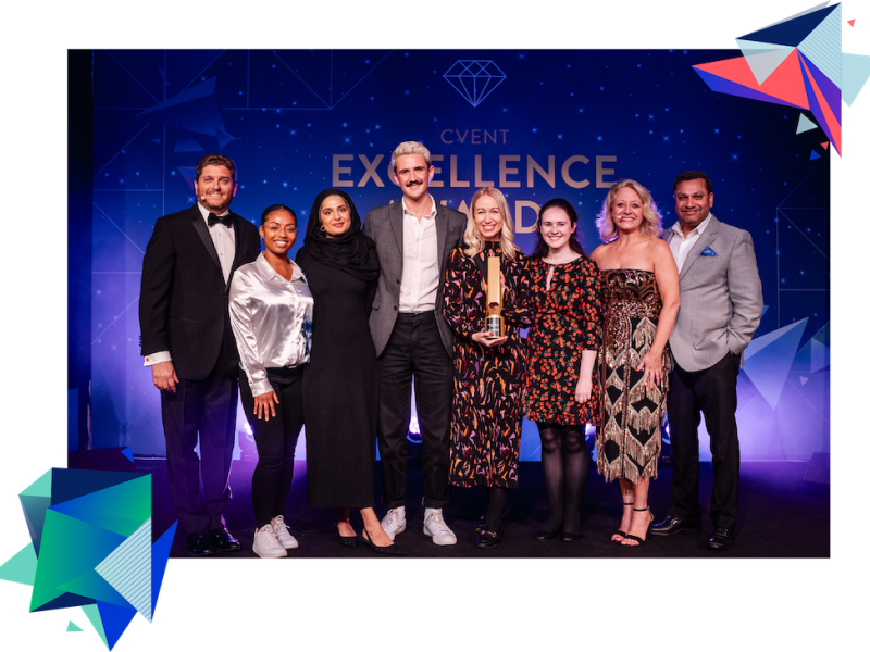 8 people posing for a photo with an award and a backdrop saying 'event excellence award'