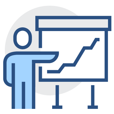 A man is standing and pointing at a line graph on a screen in a boardroom.
