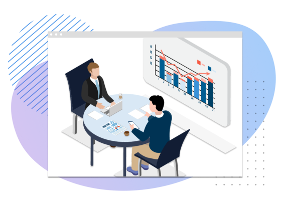 Two people sitting in front of a table with a computer and papers, and a graph on the wall.