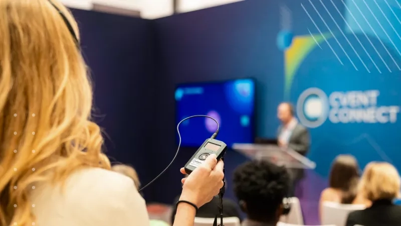 Woman with headphones and a device in her hand at an Event Connect event.